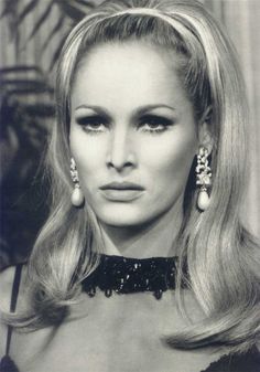 an old black and white photo of a woman with long blonde hair wearing large earrings