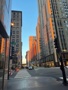 an empty city street with tall buildings on both sides and traffic lights in the middle