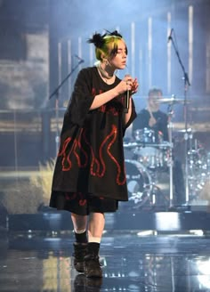 a woman standing on top of a stage holding a microphone