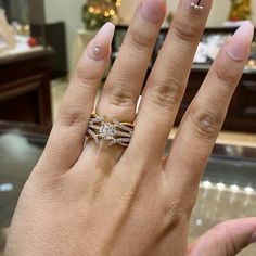 a woman's hand with two wedding rings on top of her finger and the other ring