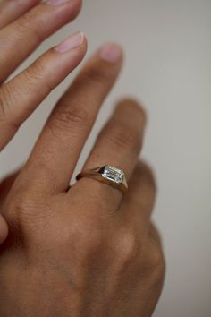 a woman's hand with a ring on it and a diamond in the middle