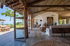 the inside of a house with wood floors and large glass doors leading to an ocean view