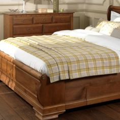 a bed sitting on top of a wooden floor next to a dresser