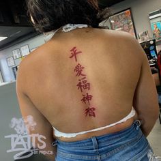 the back of a woman's upper body with chinese writing on her left shoulder