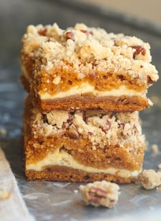 three pieces of cake sitting on top of a metal tray next to some walnuts