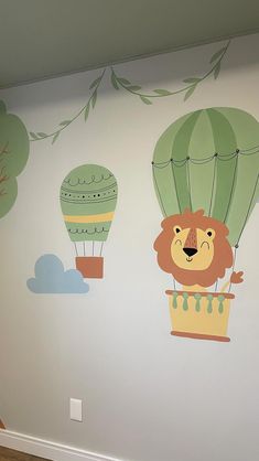 this is a child's room painted with hot air balloons and lions on the wall