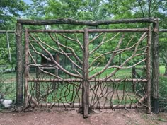 a gate made out of branches in the middle of a park