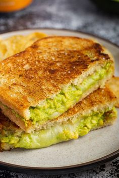 a grilled sandwich with guacamole and chips on a plate