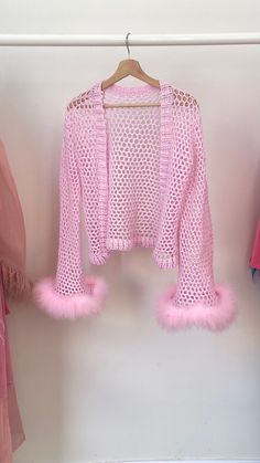 a pink sweater hanging on a clothes rack