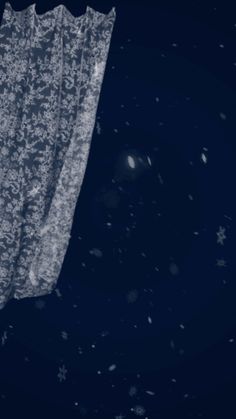 an image of a curtain hanging in the air with snow falling all over it and stars around