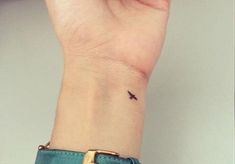 a small bird tattoo on the wrist