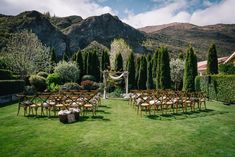 an outdoor ceremony setup with wooden chairs and tables