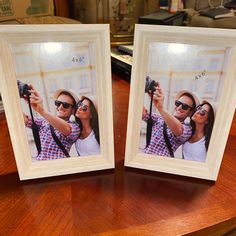 two wooden frames holding photos on top of a table