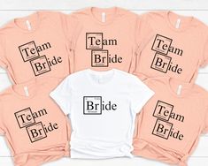 the team bride t - shirts are available in pink and white, with black letters on them