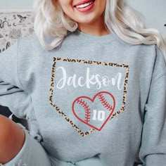 a woman with blonde hair wearing a sweatshirt that says jacksonville on it and has a baseball in the heart