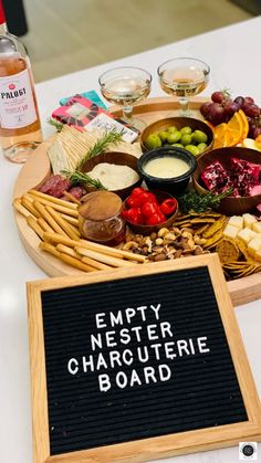 a platter filled with different types of food and wine glasses on top of a table