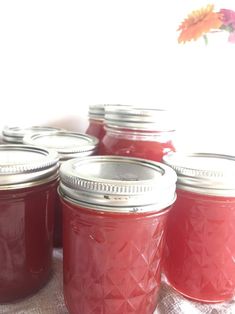 several jars filled with red liquid sitting on top of a table