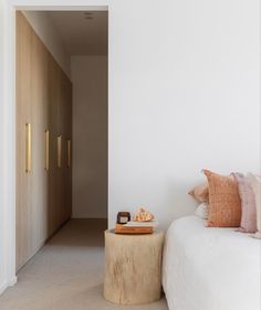 a white bed sitting next to a wooden door