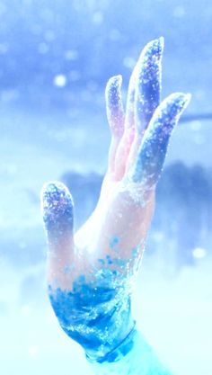 the hand is covered in blue and white powder as if it were frozen or snowing