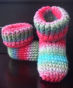 two knitted baby booties sitting on top of a table