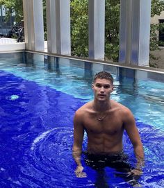 a man standing in a pool with no shirt on