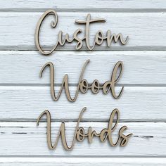 two wooden words that say custom wood words on white painted wood planks with the word,'custom wood words'in curs