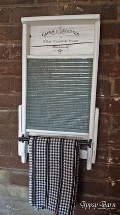 an old window is hung on the side of a brick wall with a towel rack attached to it