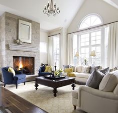 a living room filled with furniture and a fire place in the middle of a room