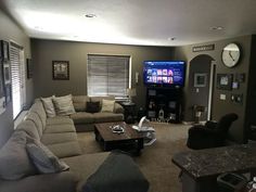 a living room filled with furniture and a flat screen tv mounted to the side of a wall