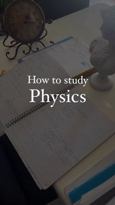 an open notebook sitting on top of a desk next to a clock and pen with the words how to study physics