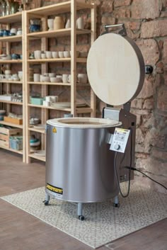 a large metal pot sitting on top of a rug in front of a brick wall