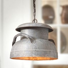 an old fashioned light fixture hanging from a chain in front of a wall with windows