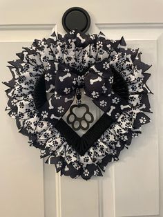 a black and white dog themed wreath hanging on the front door with a paw print