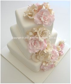 a three tiered cake with pink and white flowers on it's top layer