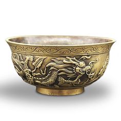 a brass bowl with dragon designs on it