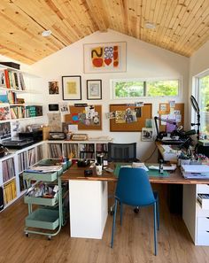 a home office with lots of clutter on the desk and shelves full of books