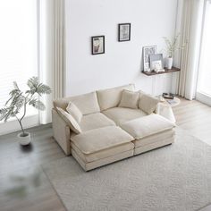 a living room filled with furniture and a white rug on top of a hard wood floor