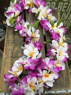 purple and white flowers are arranged on a wooden pallet