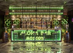 a bar with neon lights and stools in front of the bar counter that says aloha bar moon