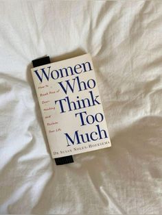 the book women who think too much is laying on top of a white bed sheet