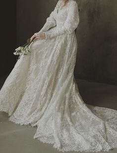 a woman in a long white dress holding a bouquet