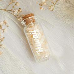 a bottle filled with shredded paper sitting on top of a white cloth covered tablecloth