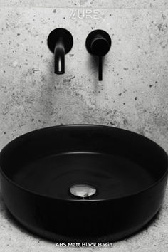 a black bathroom sink sitting under a faucet