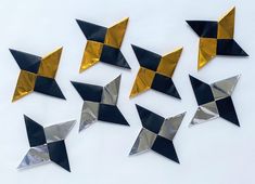 several black and gold paper airplanes on a white surface