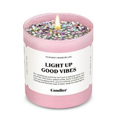 a pink candle that says, light up good vibes on it's side