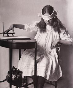 an old photo of a woman sitting at a desk