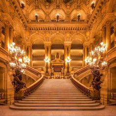 an ornate building with stairs and chandeliers