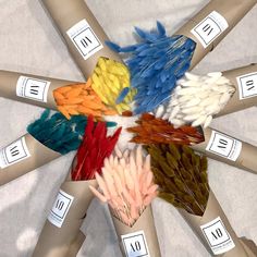 a bunch of different colored feathers arranged in a circle on top of each other with price tags