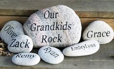 some rocks with names on them sitting next to each other and the words our grandkids rock written on them