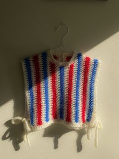 a red, white and blue sweater hanging on a wall